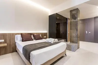 a bedroom with a large bed and a bathroom at North Station PEN-SUITES in Valencia