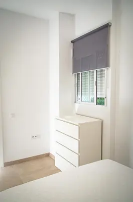 a white kitchen with a window and a dresser at Casa vacacional El Sol in Turís