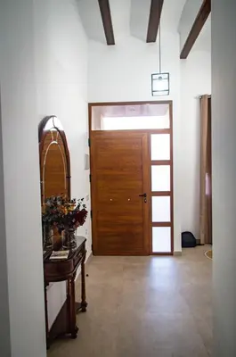 a hallway with a wooden door and a table with flowers at Casa vacacional El Sol in Turís