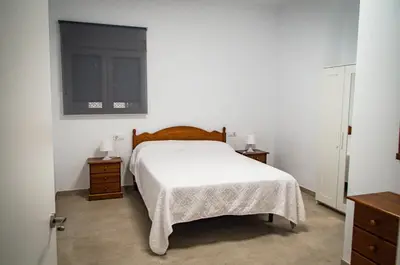 a bedroom with a white bed and two night stands at Casa vacacional El Sol in Turís