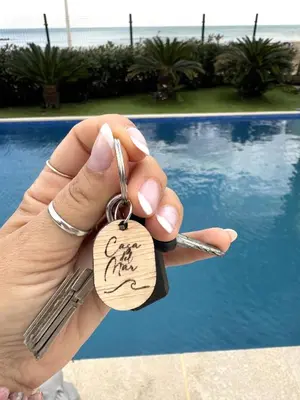 a person holding up a key chain with a key ring at Casa Del Mar, piscina privada frente al mar in Cullera