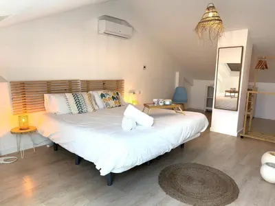 a bedroom with a large bed with white sheets and pillows at Casa Del Mar, piscina privada frente al mar in Cullera