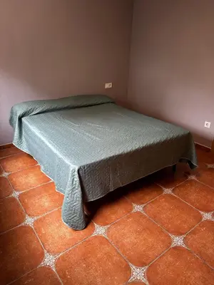 a bed in a room with a tiled floor at Villa Rosa Rasero in Serratella