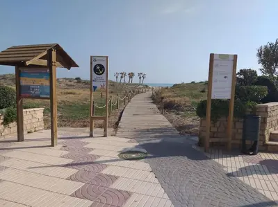 a sidewalk with signs on the side of a beach at Luminoso piso en edificio de canet de berenguer in Canet de Berenguer