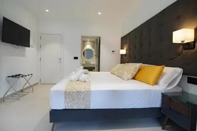 a bedroom with a large white bed with yellow pillows at BET Apartments - Suites Puerto Valencia in Valencia