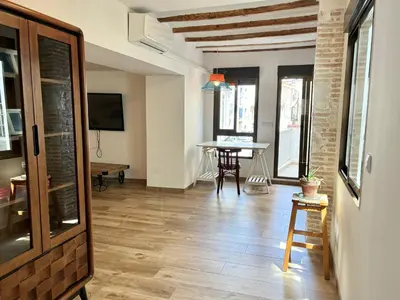 a living room with a table and a table at Apartamento artístico en el centro de Segorbe in Segorbe