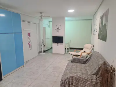 a living room with a couch and a tv at Edificio El Sol in Cullera
