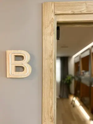 a letter sign on a wall next to a mirror at The POD Suite Hostel Blasco in Valencia