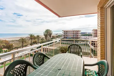 a table and chairs on a balcony with a view of the beach at Alquiler de temporada Canet Playa - en primera linea in Canet de Berenguer