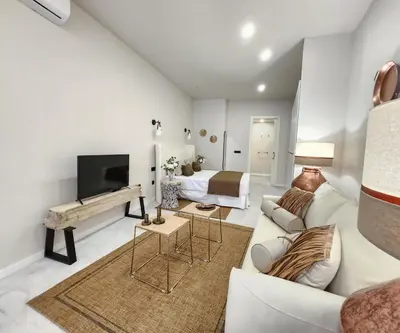 a white living room with a couch and a television at MD Pare Presentat in Valencia