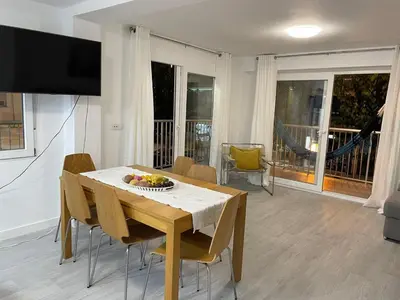 a dining room with a table with a bowl of fruit on it at NEW STYLISH BEACH FRONT APARTMENT in Cullera