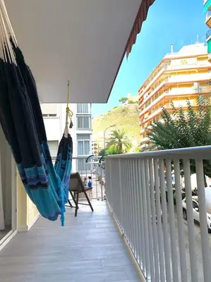 a hammock is hanging on a balcony with a view at NEW STYLISH BEACH FRONT APARTMENT in Cullera
