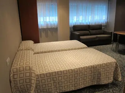 a bedroom with a large bed and a couch at Apartamentos Abastos in Valencia