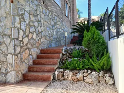 a stone wall and stairs in front of a house at Casa en Valencia, piscina, cerca de golf, playas, moto Gp in Valencia