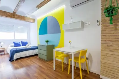 a bedroom with a bed and a table and yellow chairs at RUZAFA COOL LOFT in Valencia