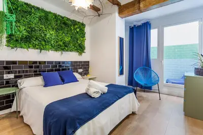 a bedroom with a bed and a green wall at RUZAFA COOL LOFT in Valencia