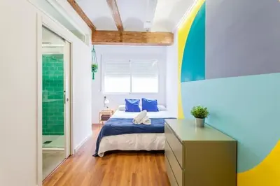 a bedroom with a bed with a blue and yellow wall at RUZAFA COOL LOFT in Valencia