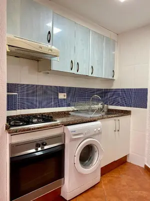 a kitchen with a washing machine and a washer at Sol y Mar in Puebla de Farnals