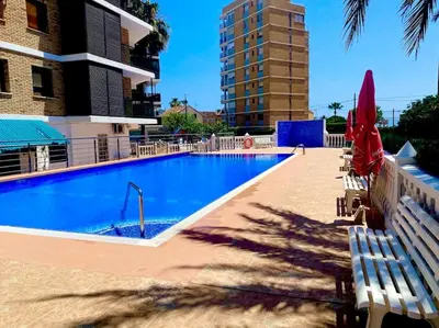a large swimming pool with chairs and a building at Sol y Mar in Puebla de Farnals