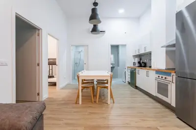 a kitchen with a table and a small table in a room at 10 pax, AC, Wifi gratis, Ciudad Artes y Ciencias in Valencia