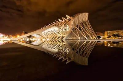 a reflection of a building in the water at night at 10 pax, AC, Wifi gratis, Ciudad Artes y Ciencias in Valencia