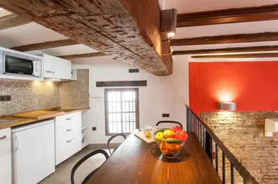 a kitchen with a wooden table with a bowl of fruit on it at Next to Central Market, Cathedral and Town Hall in Valencia