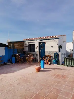 a patio with a table and chairs and a building at ROSA in Llaurí