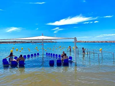 a group of people in the water at the beach at Brisa Marina in Las Canteras