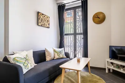 a living room with a blue couch and a table at Charming and Comfortable Apartment with Inviting Atmosphere in Valencia