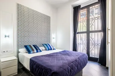 a bedroom with a bed with blue pillows and a window at Charming and Comfortable Apartment with Inviting Atmosphere in Valencia