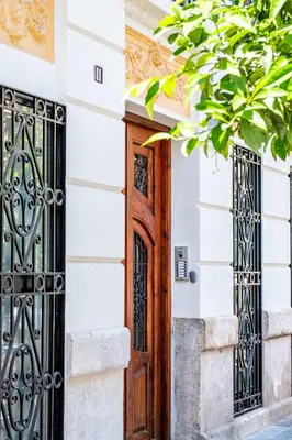 a wooden door on a white building with wrought iron gates at Beautiful Suite with Private Terrace in Valencia