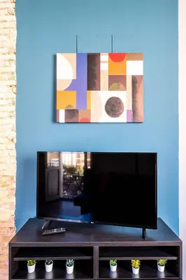 a living room with a television and a blue wall at Well Lit and Creatively Designed Apartment in Valencia