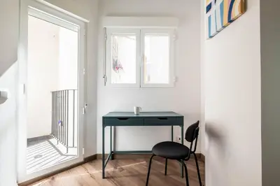 a black desk in a room with a window at Well Lit and Creatively Designed Apartment in Valencia