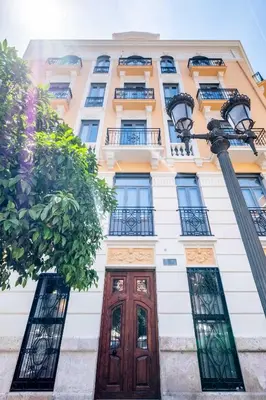 a tall white building with a wooden door and windows at Beautifully Designed Studio with Lots of Natural Light in Valencia