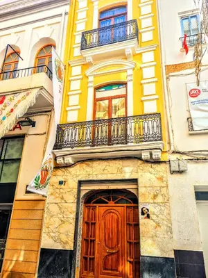 a building with a wooden door and a balcony at LA TRAVIATA - Buñol in Buñol
