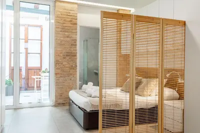 a bedroom with a bed and a large wooden closet at ApartUP Las Arenas Beach in Valencia