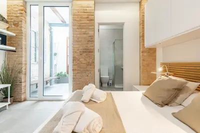 a bedroom with a bed with towels on it at ApartUP Las Arenas Beach in Valencia