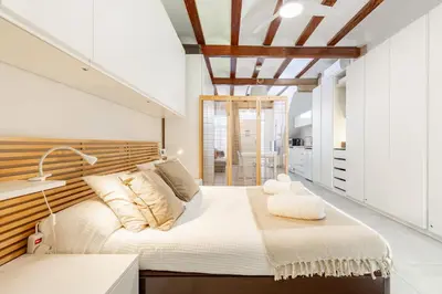 a bedroom with a large bed with a wooden headboard at ApartUP Las Arenas Beach in Valencia
