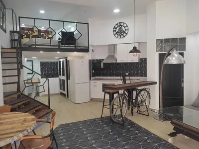 a kitchen with a table and a bike in a room at Loft puerto de Valencia in Valencia
