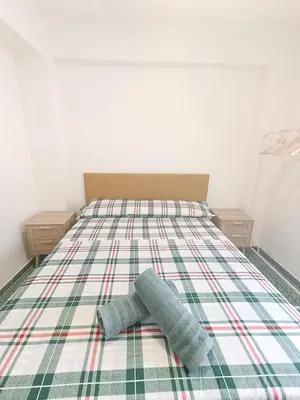 a bed with two pillows on top of it at Apartamento Lyon in Cullera