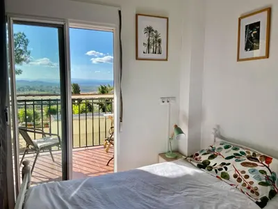 a bedroom with a bed and a balcony with a view at Beautiful Villa with huge private pool and vineyard view in Valencia