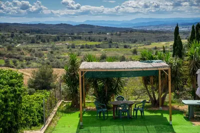 a garden with a table and chairs and a view at Beautiful Villa with huge private pool and vineyard view in Valencia