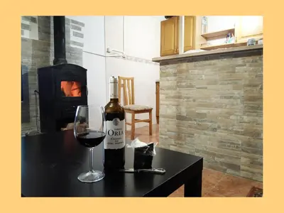 a bottle of wine and a glass on a table at Casa de pueblo García Marquez in Geldo