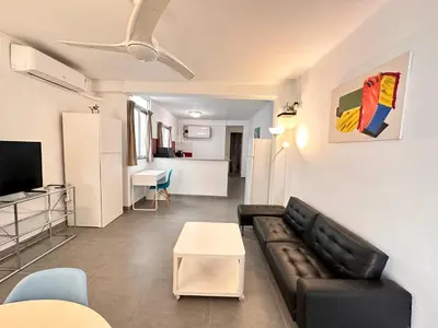 a living room with a black leather couch and a table at Malvarrosa Beach in Valencia