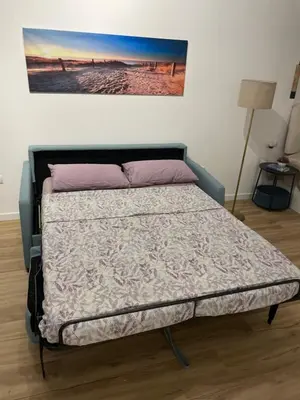 a bed in a room with a painting on the wall at Carbonell by VivoGCFlats in Valencia