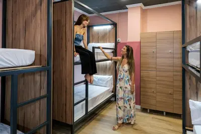 two women standing in a room with bunk beds at SOM Hostel Valencia in Valencia