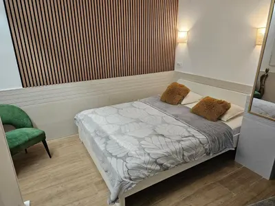 a bedroom with a bed and a green chair at Las Artes Hlius Luxury Apartments in Valencia