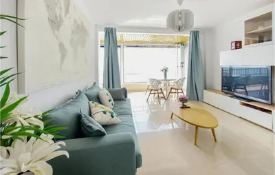 a living room with a blue couch and a table at 1 Bedroom Nice Apartment In Cullera in Cullera