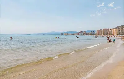 a group of people in the water at the beach at 1 Bedroom Nice Apartment In Cullera in Cullera