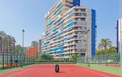 a tennis court in front of a tall building at 1 Bedroom Nice Apartment In Cullera in Cullera